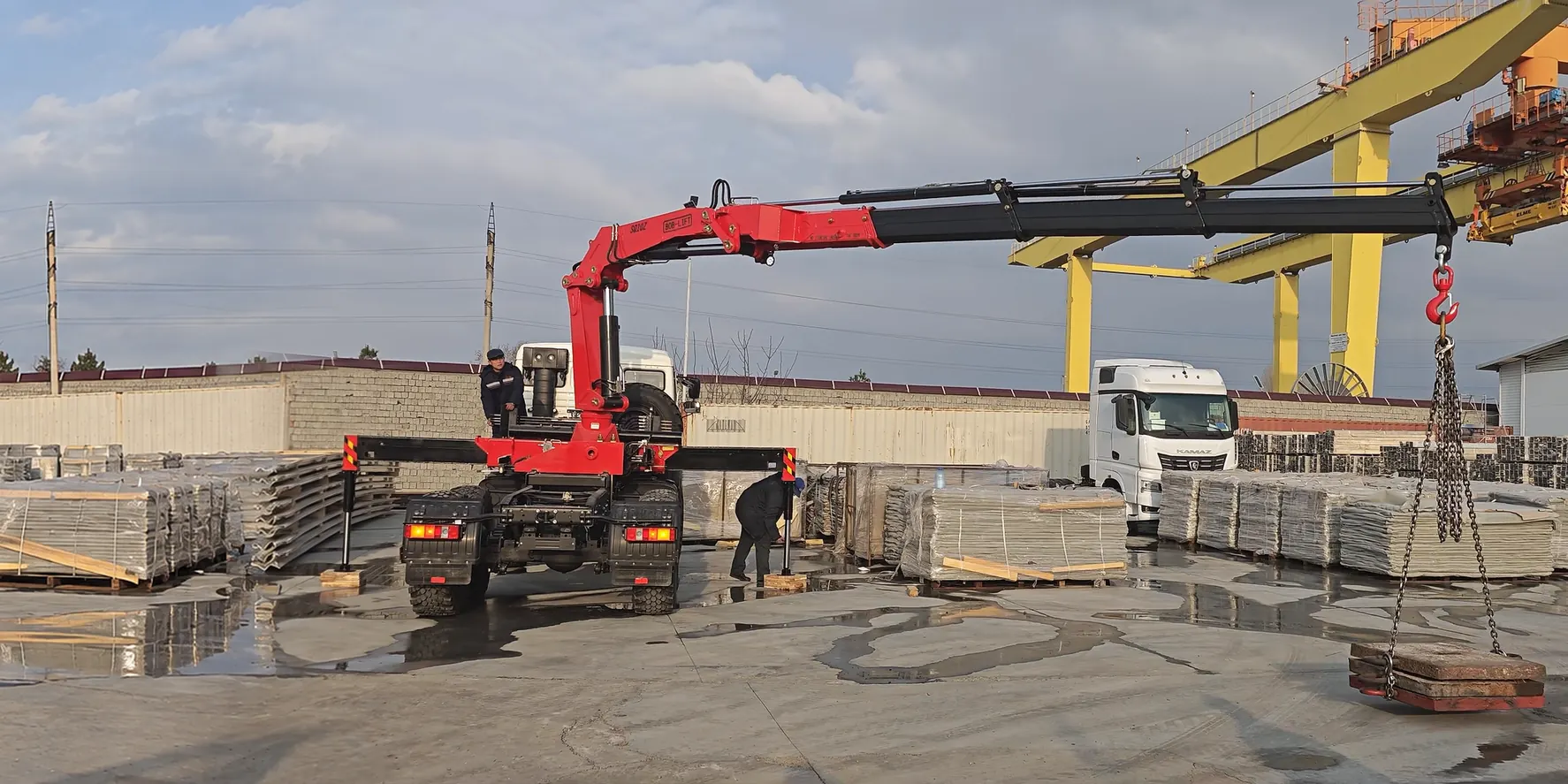 BOB-LIFT knuckle boom truck crane lifting a precast concrete panel